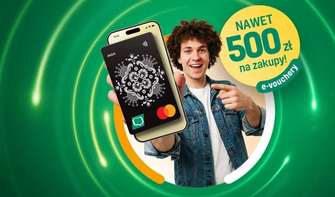 Uśmiechnięty mężczyzna wskazujący palcem na smartfon, na którym wyświetlona jest czarna karta debetowa z białym ludowym wzorem. Obok napis: "Nawet 500 zł na zakupy! e-vouchery".